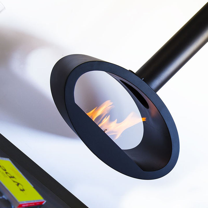 bioethanol-haengekamin-deckenmontage-ellipse-2side-ethanol-kamin-decke-schwarz-mit-flammen-modernes-wohnzimmer-vor-weisser-wand-nahaufnahme-gedreht
